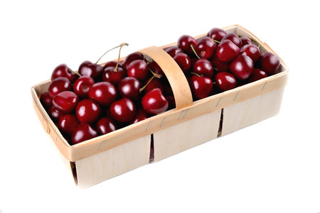Ripe natural cherries, sweet cherries in a birch bark basket on a white background, close-up selective focusの写真素材