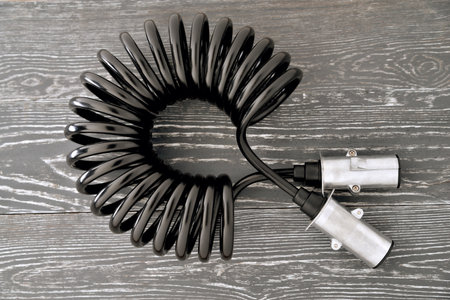 electrical Twisted cable with connectors for truck Cable for connecting a tractor to a trailer on a gray background close-up selective focusの写真素材