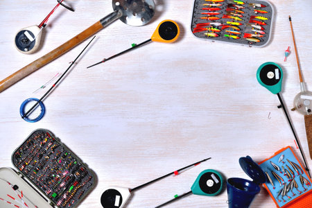 accessories for winter fishing on a light wooden background, place for an inscription
