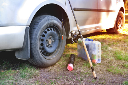 fishing accessories near a car sunny day, sunny tinted glare, preparation for fishing close-upの写真素材