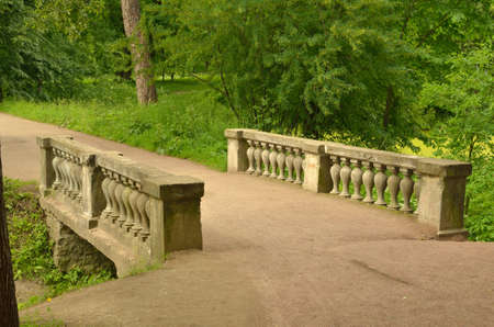 The old bridge in the Park connects the banks of a small stream.の写真素材