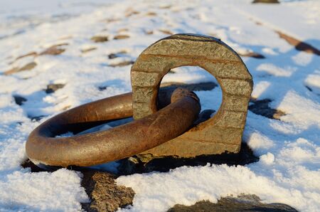 Forged ring on the waterfront of the river.To it is attached the ship with rope.の写真素材
