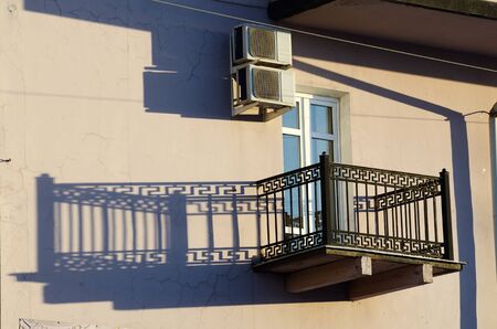 The shadow of the balcony on the wall of a building at sunset.の写真素材