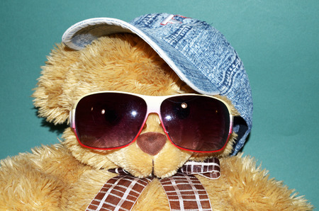 Yellow Teddy Bear wearing sunglasses and a cap .の写真素材