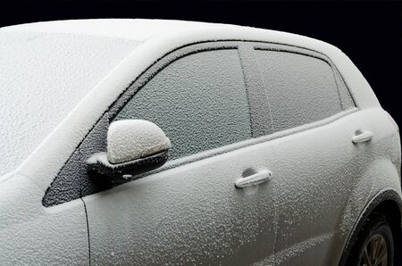 White snow lies on the roof of the car.Frost on the street.の写真素材