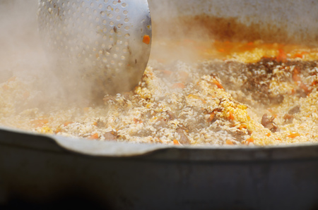 In a wide pot is preparing a large portion of barley porridge.の写真素材
