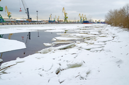In the port of the river is covered with ice.The ships are berthed.Them loaded with goods.の写真素材