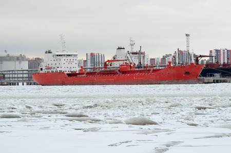 In the port of the river is covered with ice.The ships are berthed.Them loaded with goods.の写真素材