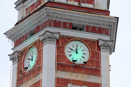 The clock on the city tower.Decorated garlands for Christmas.