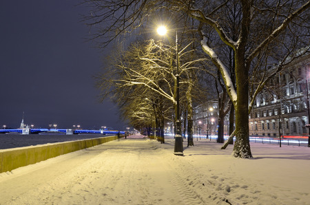 Urban street covered in white snow.The lamp lights up the area.の写真素材
