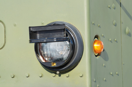 A headlight on a military truck.In the dark, the headlight illuminates the road.の写真素材