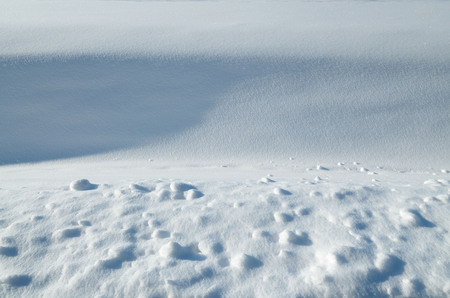 Slanting rays of the sun showing the texture of snow.の写真素材