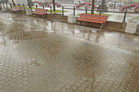 The city is pouring rain.Everywhere on the roads are puddles.Is damp and wet weather.の写真素材