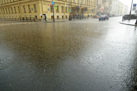 It is raining heavily in the city.On the roads are large puddles.の写真素材