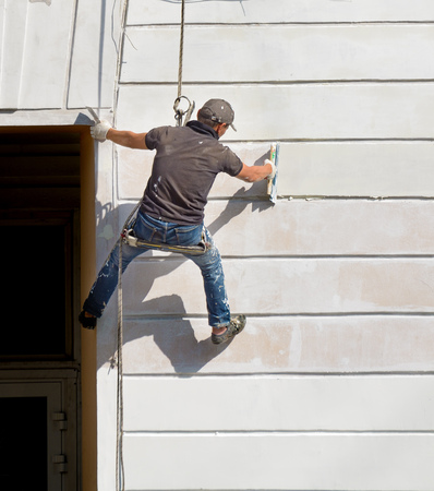 Repair of the facade of the building.Industrial climbers at work.They putty and paint the walls.の写真素材