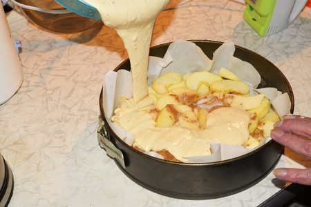 Pouring the dough into a metal mold.It will bake a cake in the oven gas stove.の写真素材