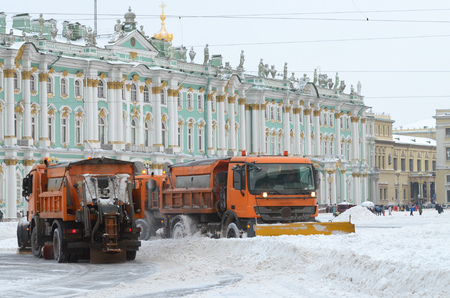 Night in the city the snow fell.His cleaning went snow-removal vehicles.They cleared the roads on the streets of the city.のeditorial素材