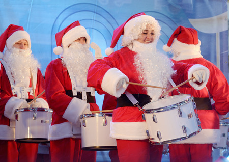 Saint-Petersburg.Russia.December.22.2018.Musicians in the form of Santa Claus.On Christmas eve give a concert in front of the audience.They play drums.Perform at the Palace square.のeditorial素材