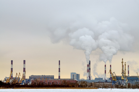 Industrial facility in the city.From long pipes goes a grey smoke.の写真素材