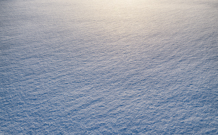 Oblique rays of the sun reflect the texture of snow.の写真素材