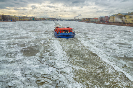 The icebreaker on a frozen river breaks the ice, which interferes with navigation.の写真素材