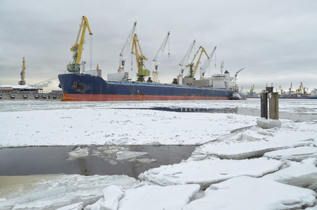 Natural landscape in the cargo port.The water in the Bay is covered with ice.On top is white snow.の写真素材