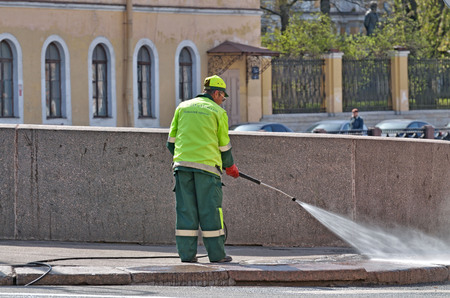 Saint-Petersburg.Russia.April.28.2019.Hydration of the city streets.Cleaners with a hose watering the street.The dust settles and the air becomes fresh .のeditorial素材