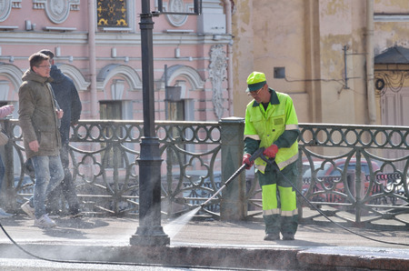 Saint-Petersburg.Russia.April.28.2019.Hydration of the city streets.Cleaners with a hose watering the street.The dust settles and the air becomes fresh .のeditorial素材