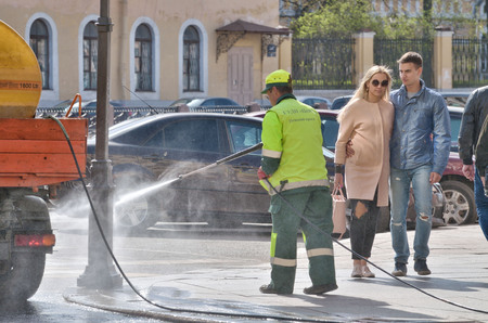 Saint-Petersburg.Russia.April.28.2019.Hydration of the city streets.Cleaners with a hose watering the street.The dust settles and the air becomes fresh .のeditorial素材