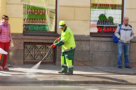 Saint-Petersburg.Russia.April.28.2019.Hydration of the city streets.Cleaners with a hose watering the street.The dust settles and the air becomes fresh .のeditorial素材