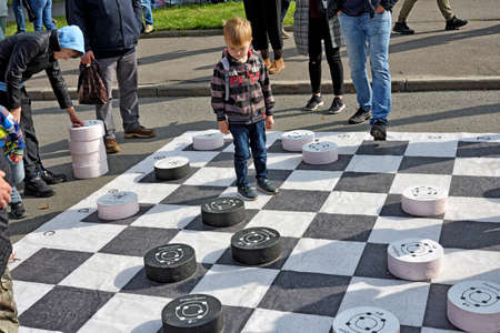 Russia, Saint Petersburg, September 20, 2020.Children play checkers on a large playing field. The game helps to develop logic and thinking in children.のeditorial素材