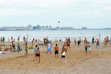 Saint Petersburg. Russia. August 9.2014. Young people play volleyball on the beach.It's a nice outdoor activity during the weekend.のeditorial素材