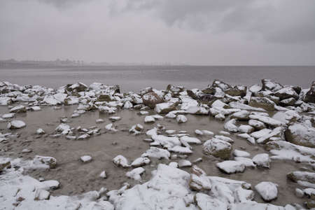 Stones by the sea. The first snow lies on them.の写真素材
