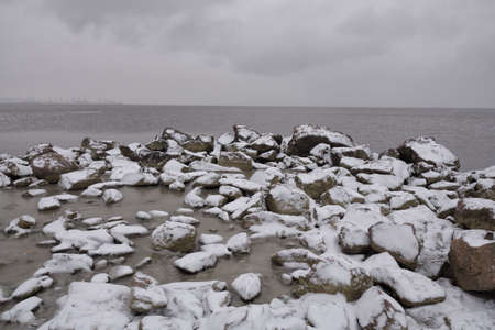 Stones by the sea. The first snow lies on them.の写真素材