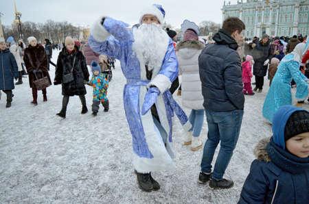 Saint-Petersburg.Russia.January 03.2022. New Year's festivities at the Palace Square Santa Claus gives gifts to children. People dance, have fun, lead round dances.のeditorial素材