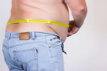 Distance measurement roulette belly man is measuring the diameter of abdomen, back view 