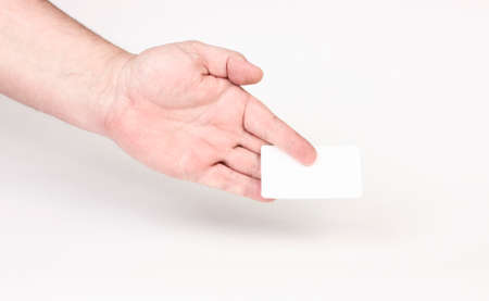 Hand holding a business card on a gray background