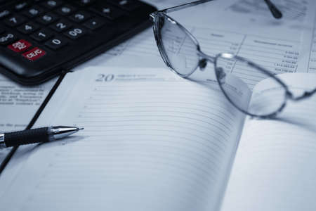 Business plan with a pen, glasses and calculator on documents.の写真素材
