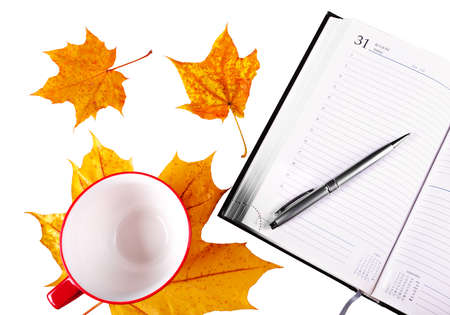 Notebook silver pen, empty mug of red color for a drink, isolated on a white background with yellow...