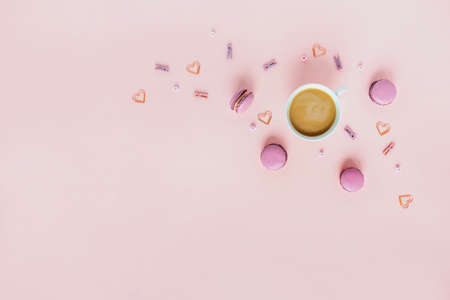 Macaroons and peonies on a pink background, greeting card.