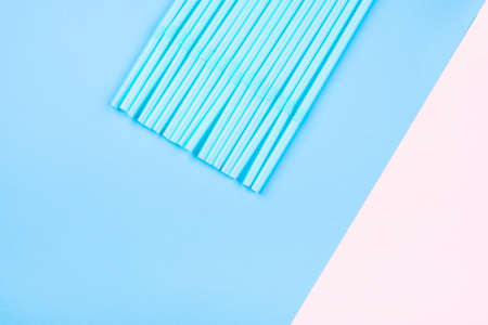 Blue-pink background of plastic straws. Flat lay, top view.