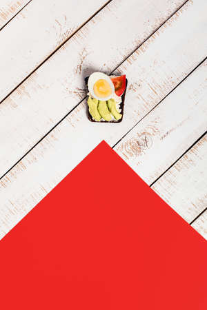 One sandwich with avocado, tomato, cream cheese on white wooden background. Food for vegetarians....
