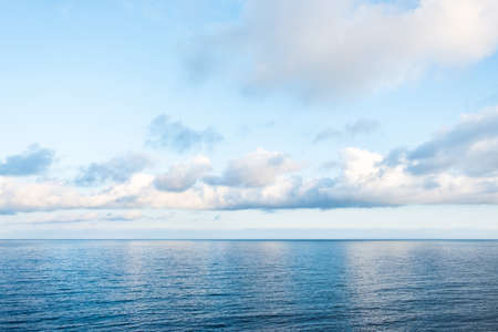 Blue and pink color background with sea and sky. Waves and clouds.の写真素材