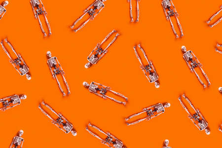 Halloween concept. White skeletons chaotically arranged on orange table. Flat-lay, top view, copy space.の写真素材