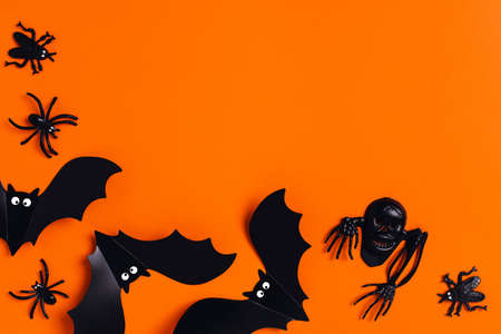 Halloween decoration concept - orange background with spiders and bats. Flat lay, top view. Place for your text.の写真素材