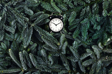 New year Christmas concert. There is not much time left before the festive celebration. Time to start celebrating. Black and white clock on green fir brunches.の写真素材
