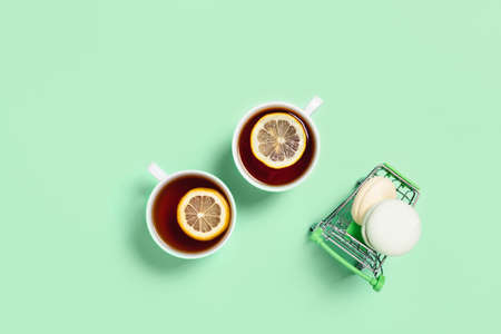 Food and drink concept. Two cups of tea with lemon and marshmallows on a food cart. Mint color. Flat lay, top view, copy space.の写真素材