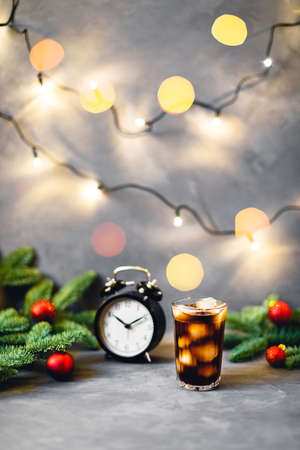 Christmas and New year composition with glass of cold coffee surrounded by fir brunches with red...