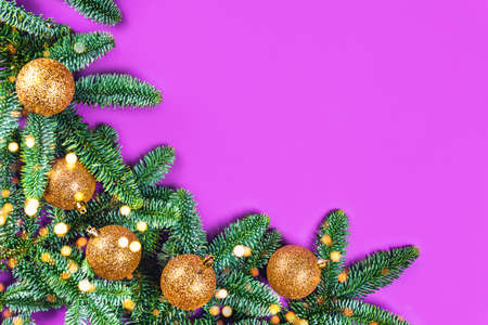 Christmas card with fir brunches, golden balls and lights on purple background. Flat lay, top view, copy space.の写真素材