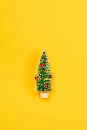 Christmas and New year yellow decorative background with one christmas tree. Flat lay, top view, copy space.の写真素材